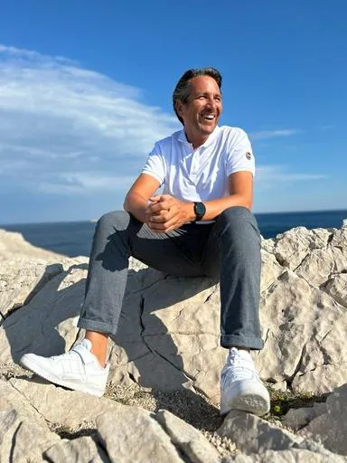 Frédéric Barret assis sur des rochers en bord de mer