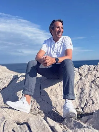 Frédéric Barret assis sur des rochers en bord de mer